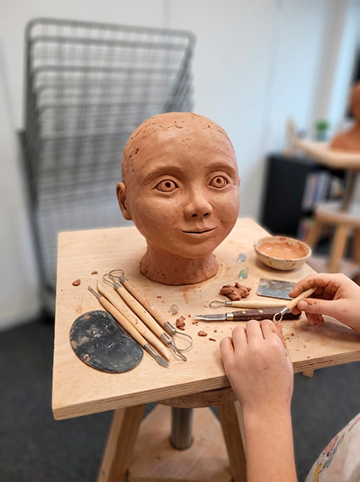 Enfant modelant une théière en argile à l'atelier de sculpture Edumanga à Vélizy-Villacoublay